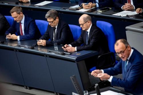 Federal Chancellor Olaf Scholz 2R , Federal Minister of Economics Robert Habeck 2L and Federal Minister of Finance Christian Lindner L look at their cell phones during the speech of CDU Chairman Friedrich Merz in the Bundestag in Berlin on December 13, 2023 plenary session in the Bundestag.