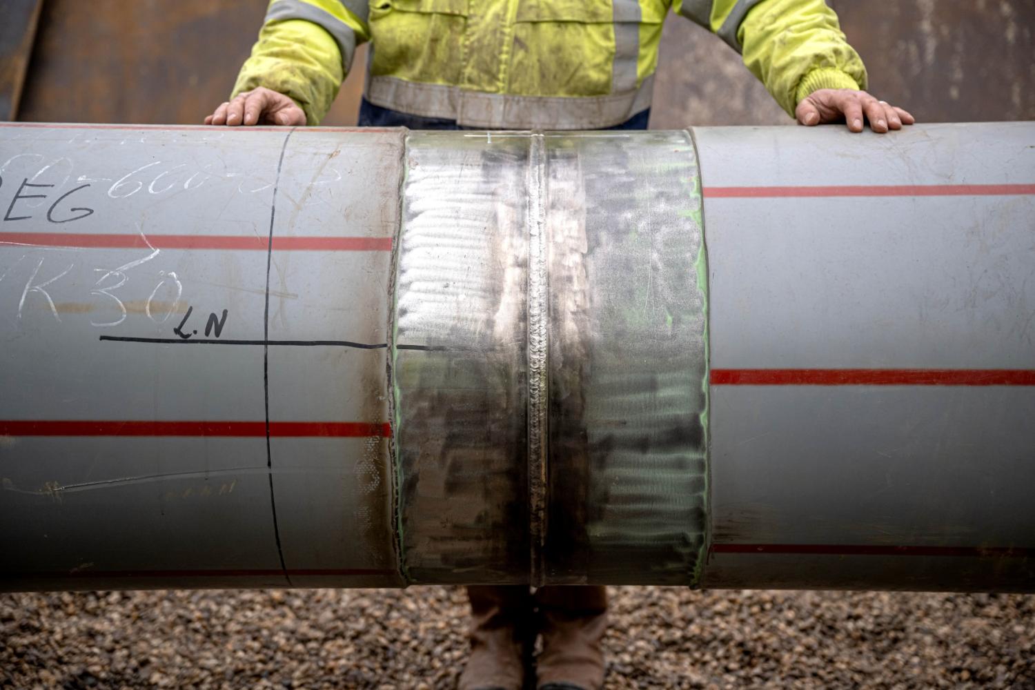 Workers inspect the last weld seam of another connecting pipeline for the LNG terminal in Wilhelmshaven.